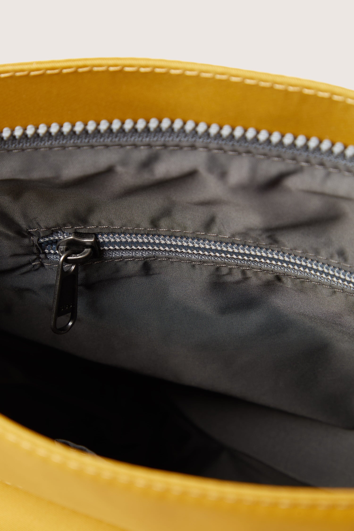 The sleek interior of a Kennington Crossbody Bag with adjustable zippers.