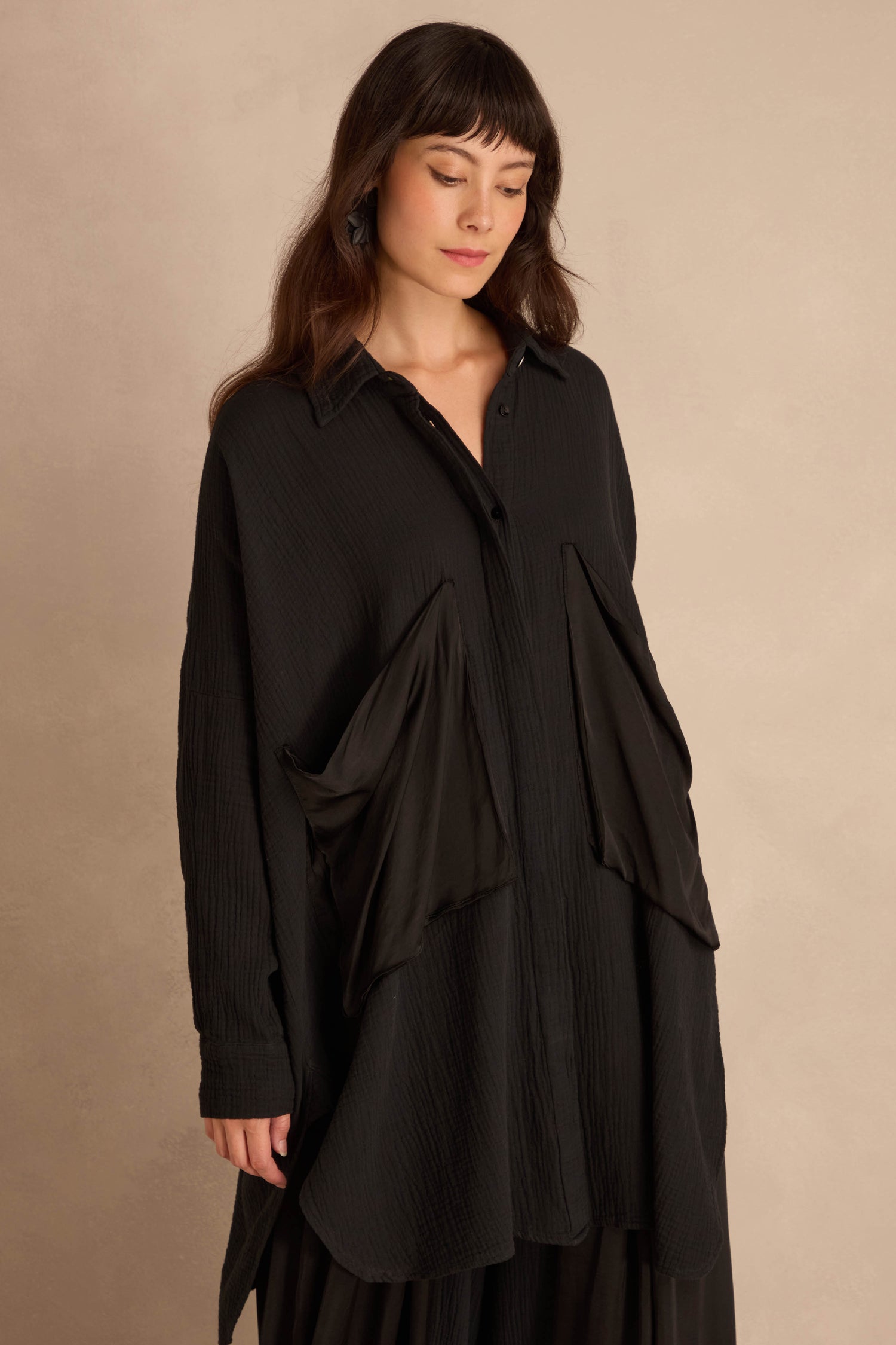 Black Pocket Satin Shirt, an oversized, long-sleeved black button-down featuring large, angled satin patch pockets on the front.