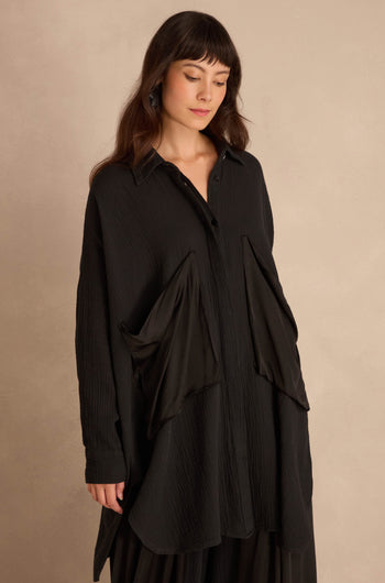 Black Pocket Satin Shirt, an oversized, long-sleeved black button-down featuring large, angled satin patch pockets on the front.