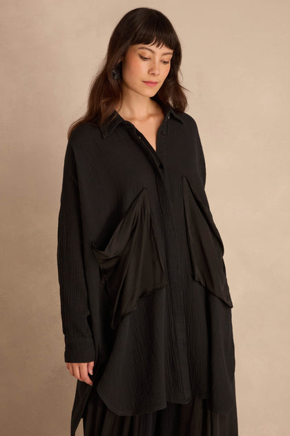 Black Pocket Satin Shirt, an oversized, long-sleeved black button-down featuring large, angled satin patch pockets on the front.