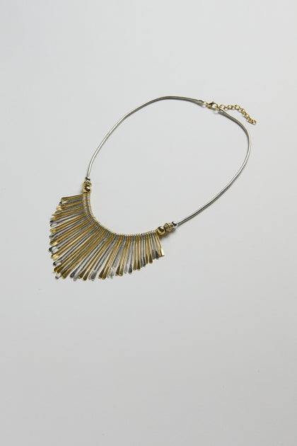 The Mixed Metal Fan Necklace features thin, elongated gold and silver-toned pendants in a fan shape, displayed on a plain white background.