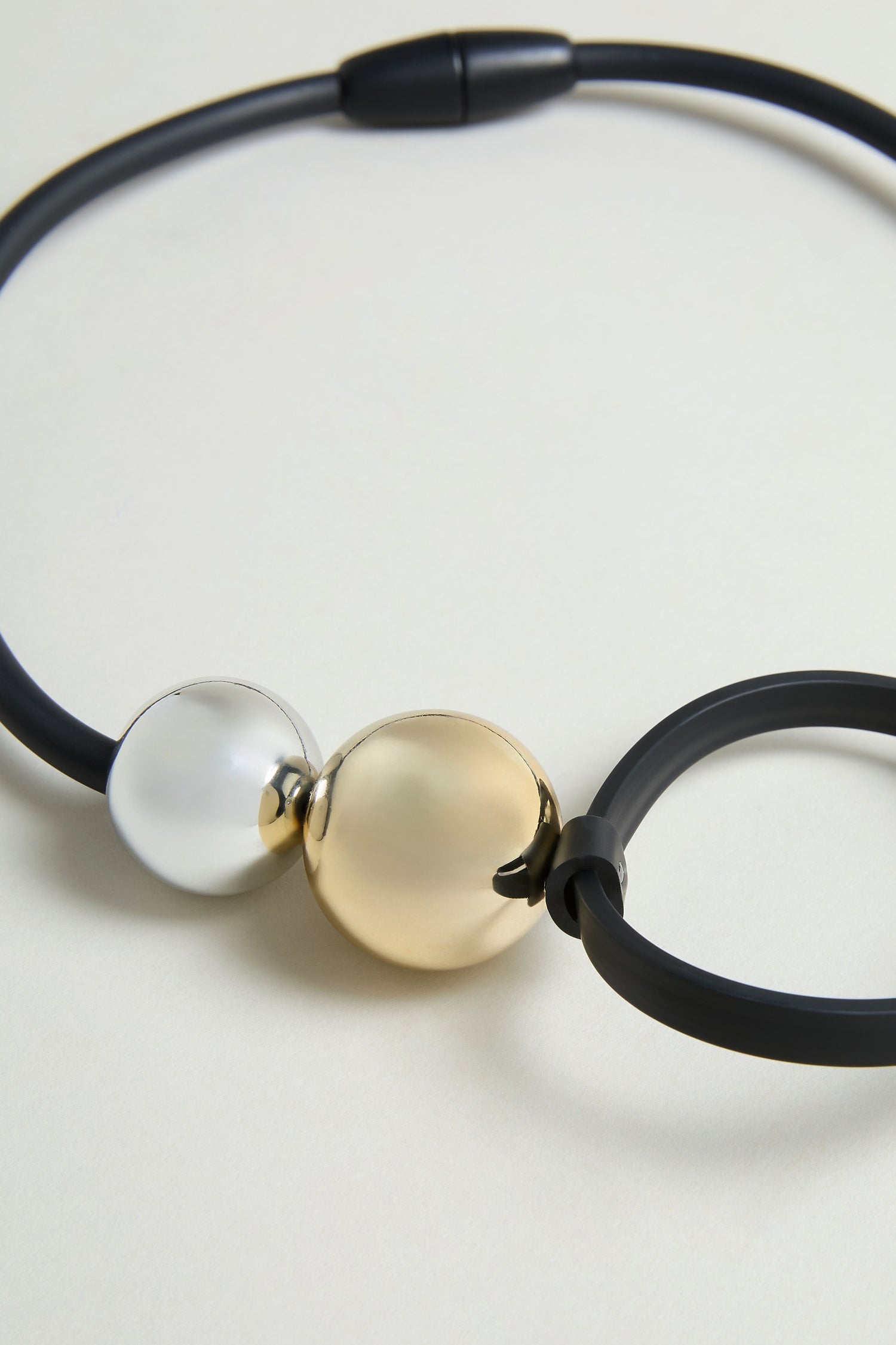 The Space Necklace features a matte black design with one silver and one gold metallic round bead at the center, accented by oversized acrylic beads for a bold statement.