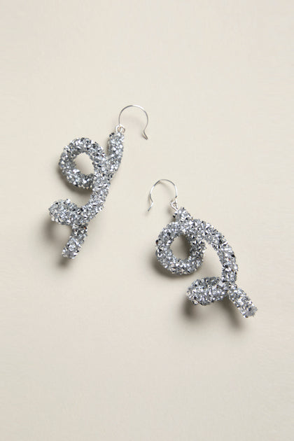 A pair of silver glitter twist earrings, artfully showcased on a light background, evoke the artistic flair of the Disco Sketch Earrings.