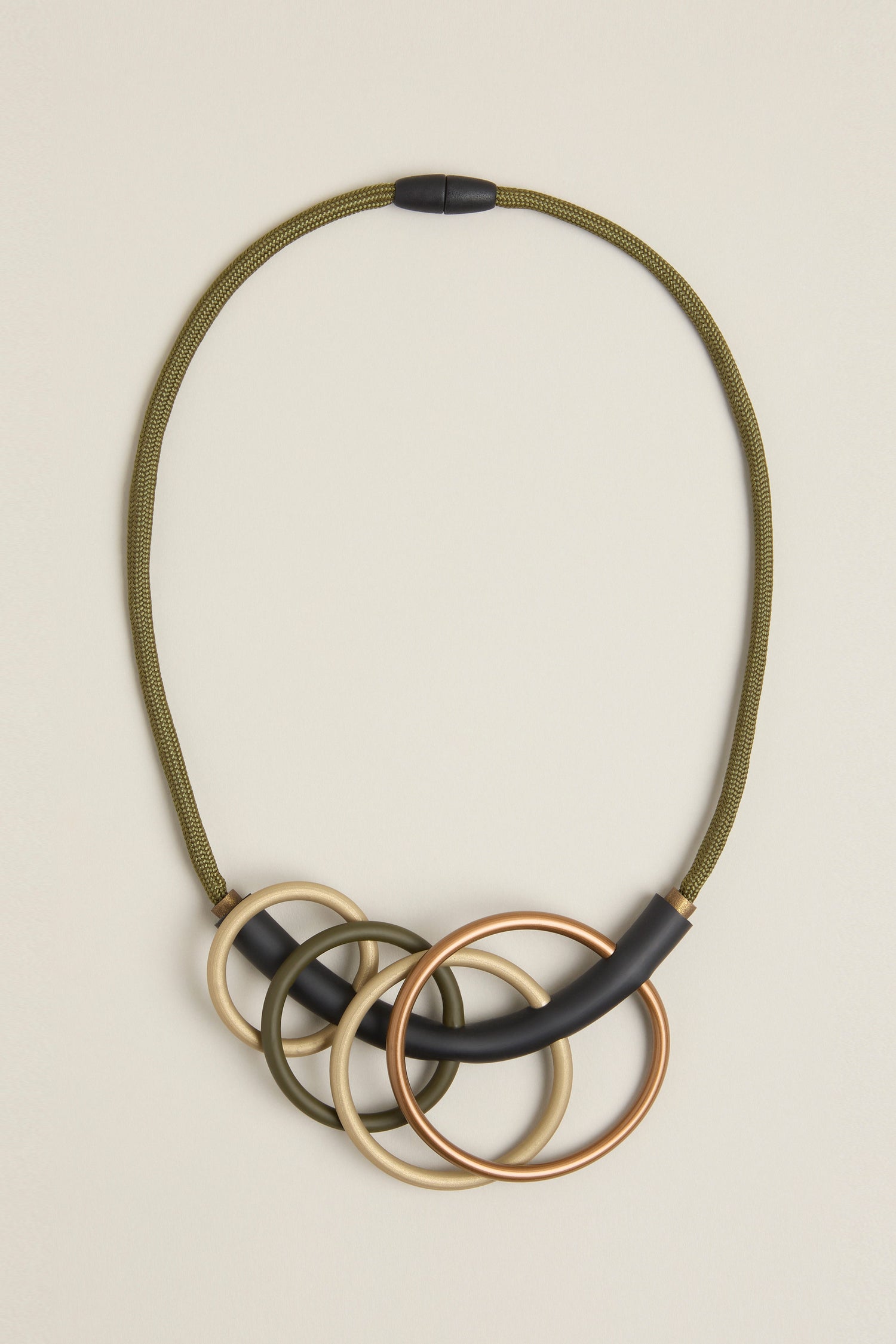 Explore the modern sophistication of Samuel Coraux's Quadruple Circles Necklace, designed with a green cord and embellished with five interlocking rings in striking gold and black tones.