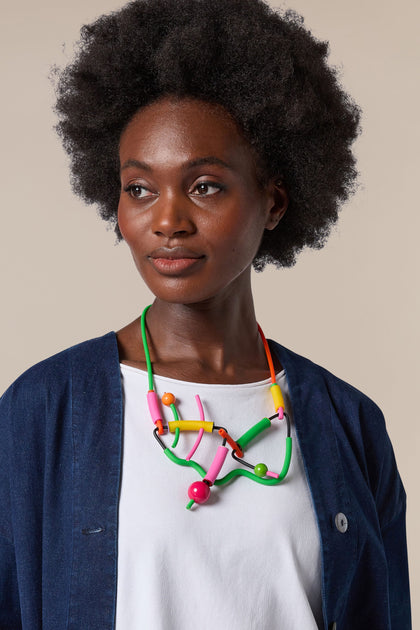 A black woman wearing a Doodle Necklace featuring wearable art.