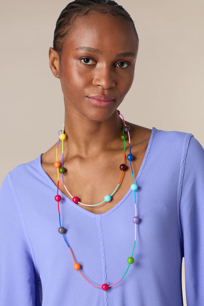 Woman wearing a Rainbow Sphere Colour Pop Necklace and a blue top.