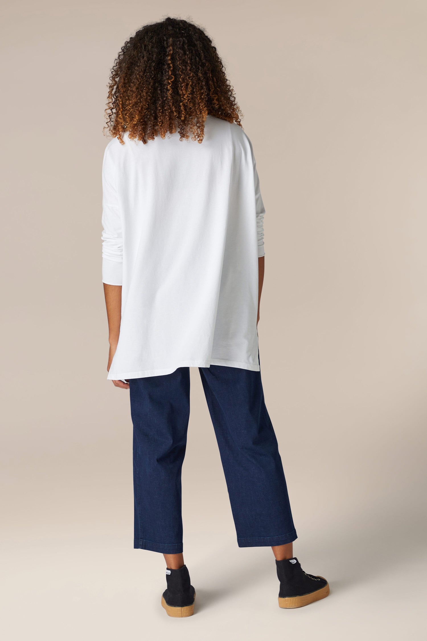 The back view of a woman wearing a comfortable Cotton Jersey Relaxed Top and blue jeans.