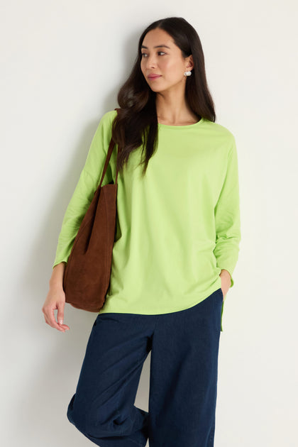 A woman wearing a Cotton Jersey Relaxed Top in green with an oversized, boxy silhouette.