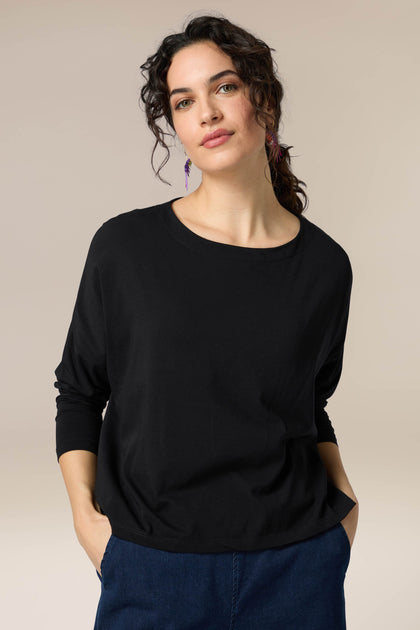 A woman wearing a Cotton Jersey Drapey Top, which is versatile and black.