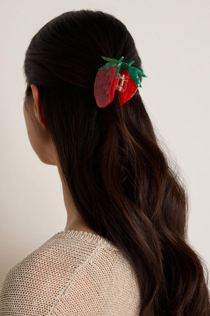 A person with long, dark hair faces away from the camera, wearing the Hand Painted Strawberry Hair Clip to hold a section of hair at the back.