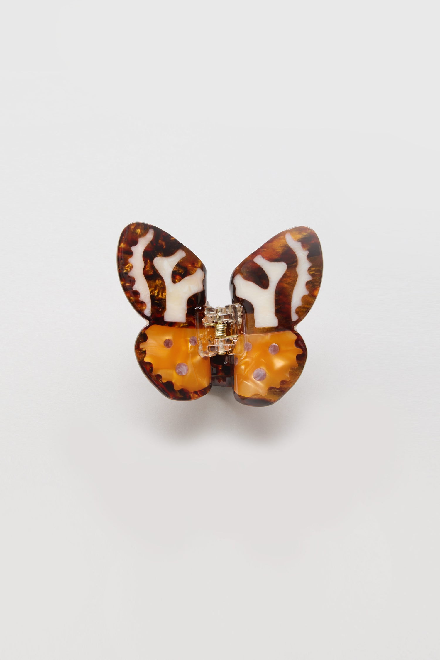 The Hand Painted Tiger Moth Hair Clip showcases a butterfly shape with brown, orange, and cream marbled patterns on a light background. Eco-friendly and ideal for adding a unique touch to your style.