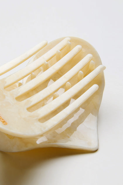 Close-up of the Hand Painted Celestial Heart Hair Clip, crafted from biodegradable cellulose acetate with a marbled pattern, shown lying on a white surface.