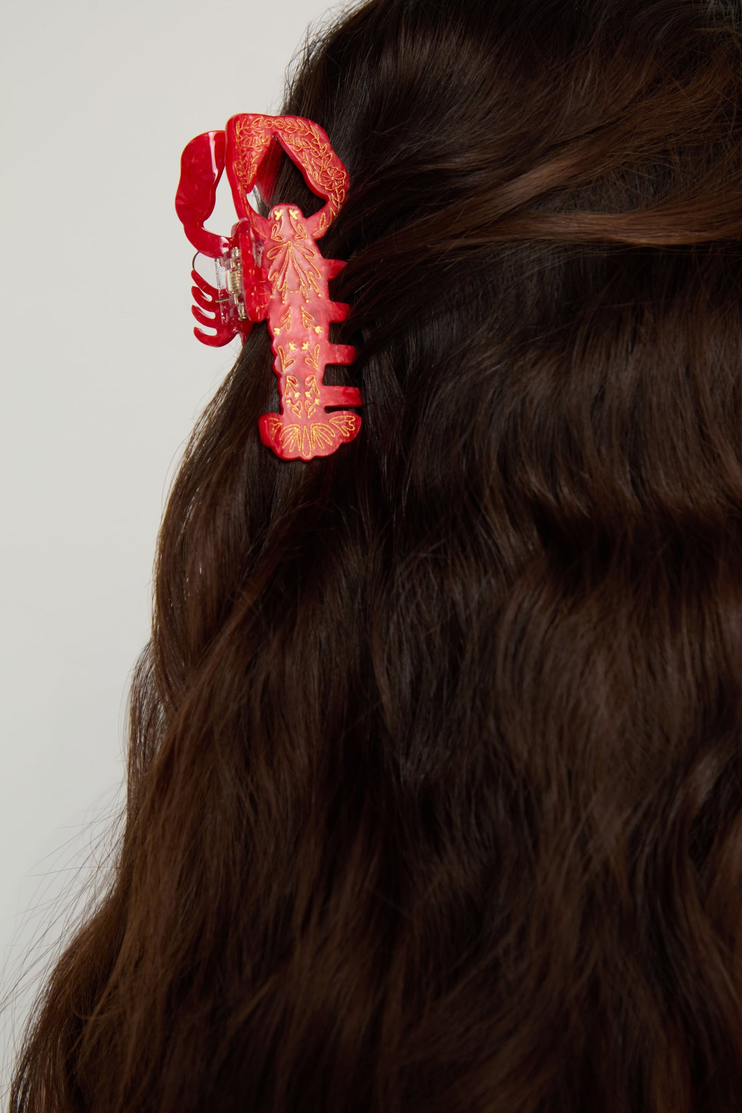 A Hand-painted Lobster Hair Clip secures dark wavy hair against a light background, adding a playful coastal accent to your accessories collection.
