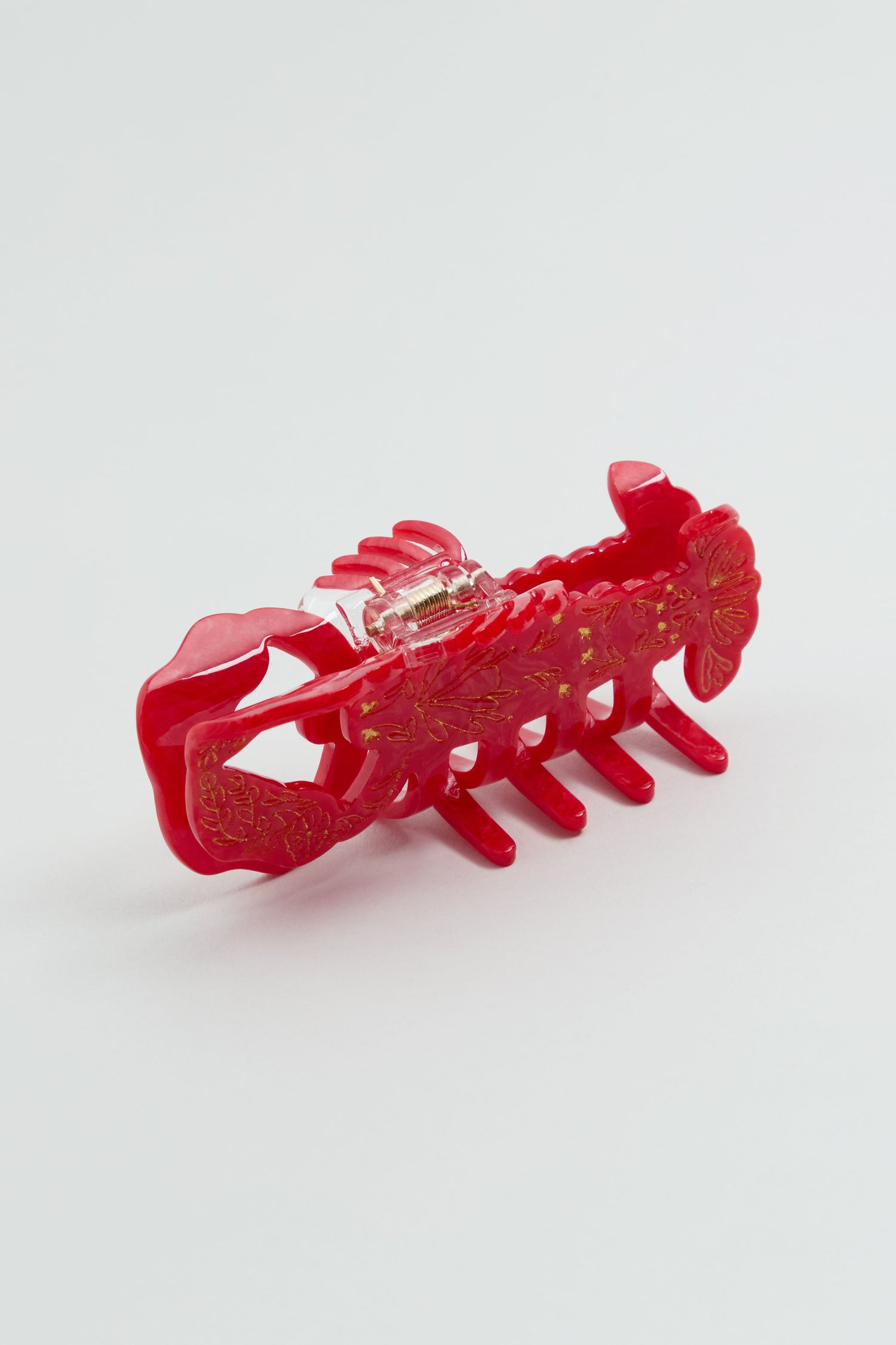The Hand-painted Lobster Hair Clip features a red plastic design with gold floral details and a spring hinge, shown on a white background—an eye-catching piece for your coastal accessories collection.