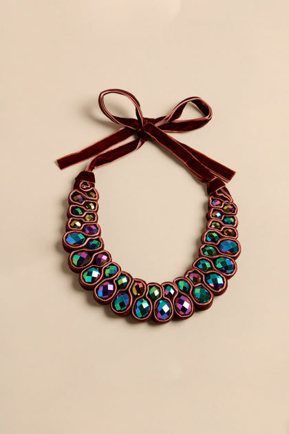 Velvet Ribbon Statement Necklace featuring iridescent crystals set in a dark velvet ribbon that ties in a bow at the top.