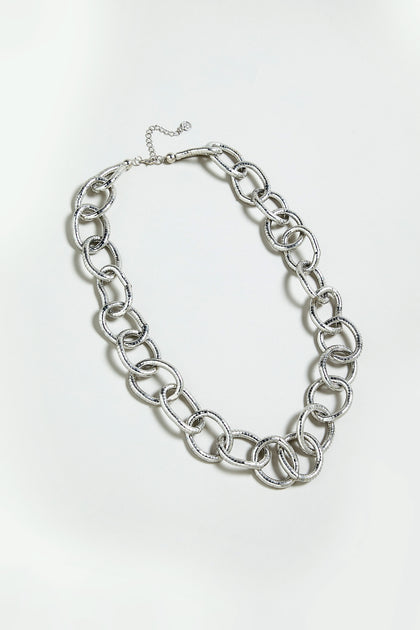 The Long Links Necklace features an oversized silver chain with large, textured interlocking links and an adjustable clasp, displayed on a plain light background.