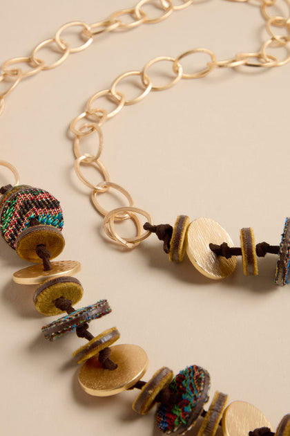 Textured Disc Necklace featuring gold-tone chain links, alternating metal discs, and colorful woven fabric circles on a brown cord.