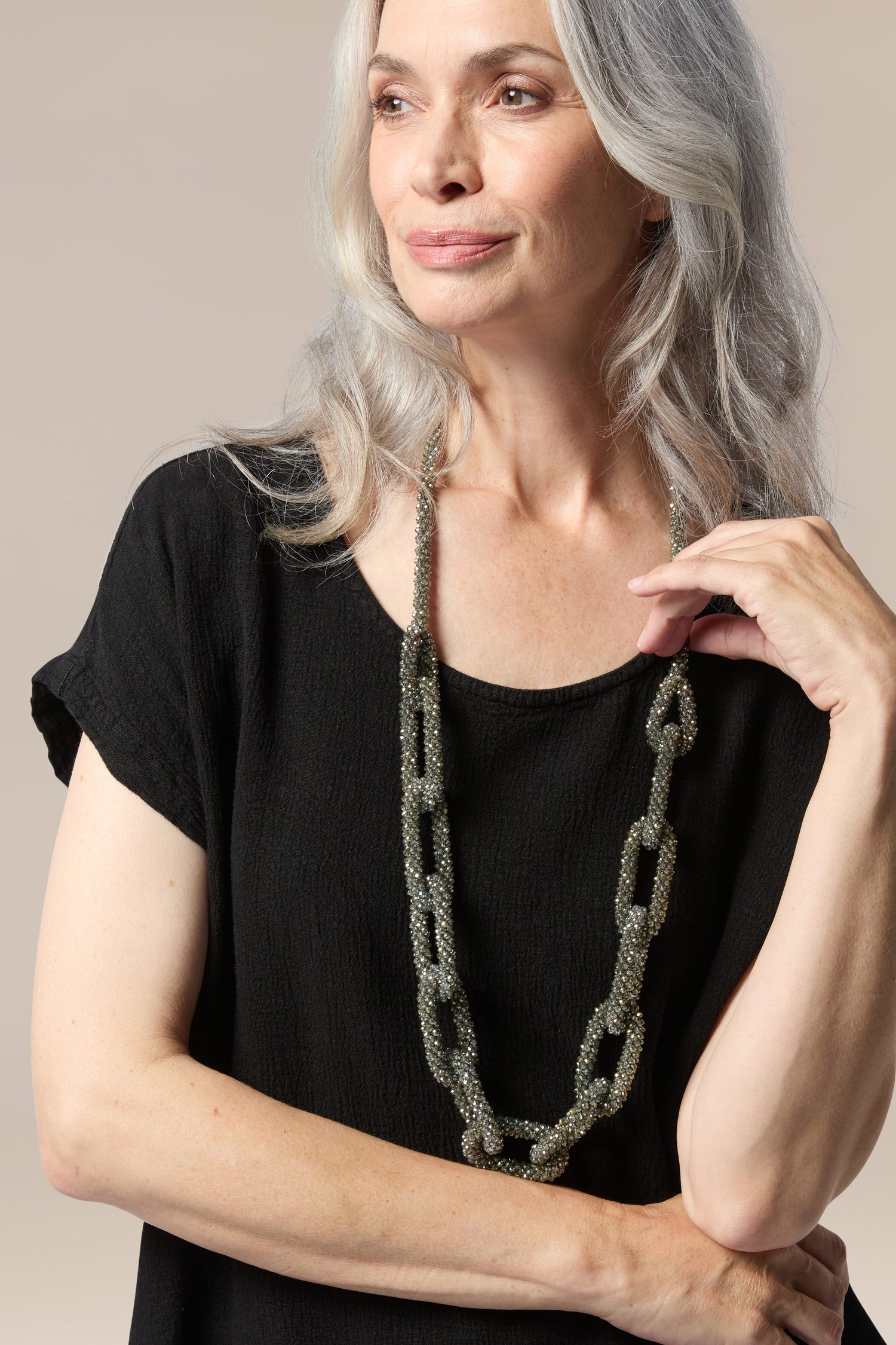 A woman wearing a black top and the Glacier Necklace.