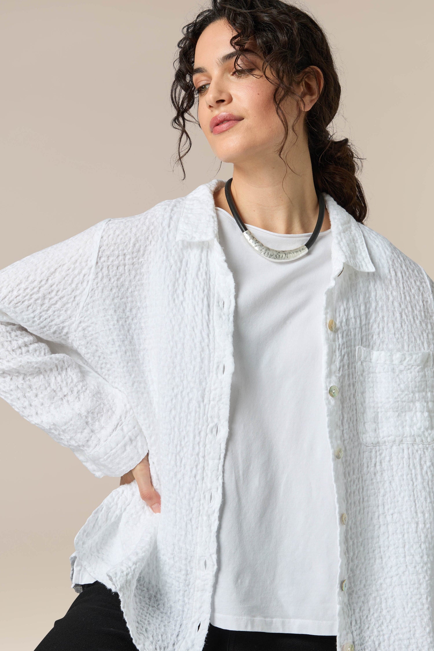 A woman wearing a unique Hammered Necklace with a white shirt and black pants.