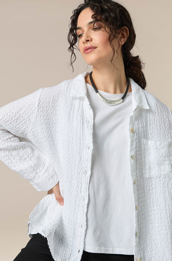 A woman wearing a unique Hammered Necklace with a white shirt and black pants.