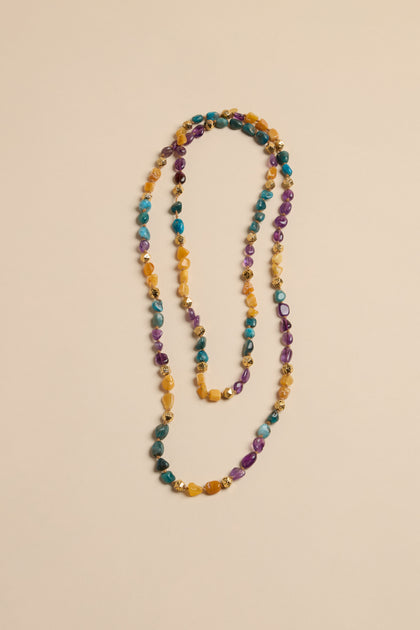 Long Rainbow Bead Necklace made of multicolored stone beads accented with small gold-toned metal spacers.