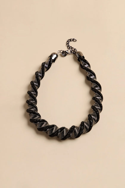 The Midnight Helix Necklace features a twisted, spiral cord of black and metallic silver segments with a gunmetal chain closure.