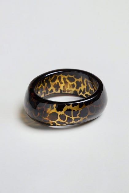 Leopard Bangle – a chunky, oval-shaped resin accessory featuring a glossy finish and an eye-catching tortoiseshell pattern, showcased on a plain white background.