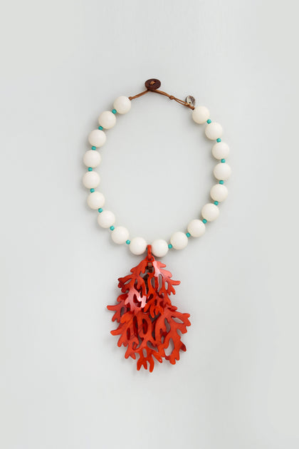 The Coral Resin Short Pendant Necklace features large white resin beads, small turquoise spacers, and a striking red coral pendant at the center.