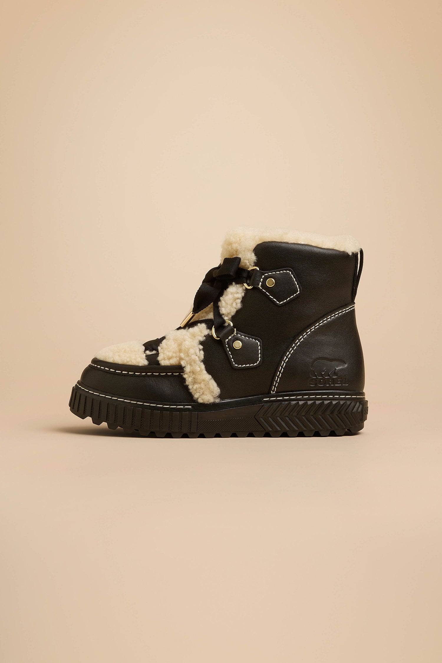 Black Sorel Leather Alpine Boots featuring a cream-colored fleece lining, metal eyelets, black laces, and a thick lugged rubber sole.