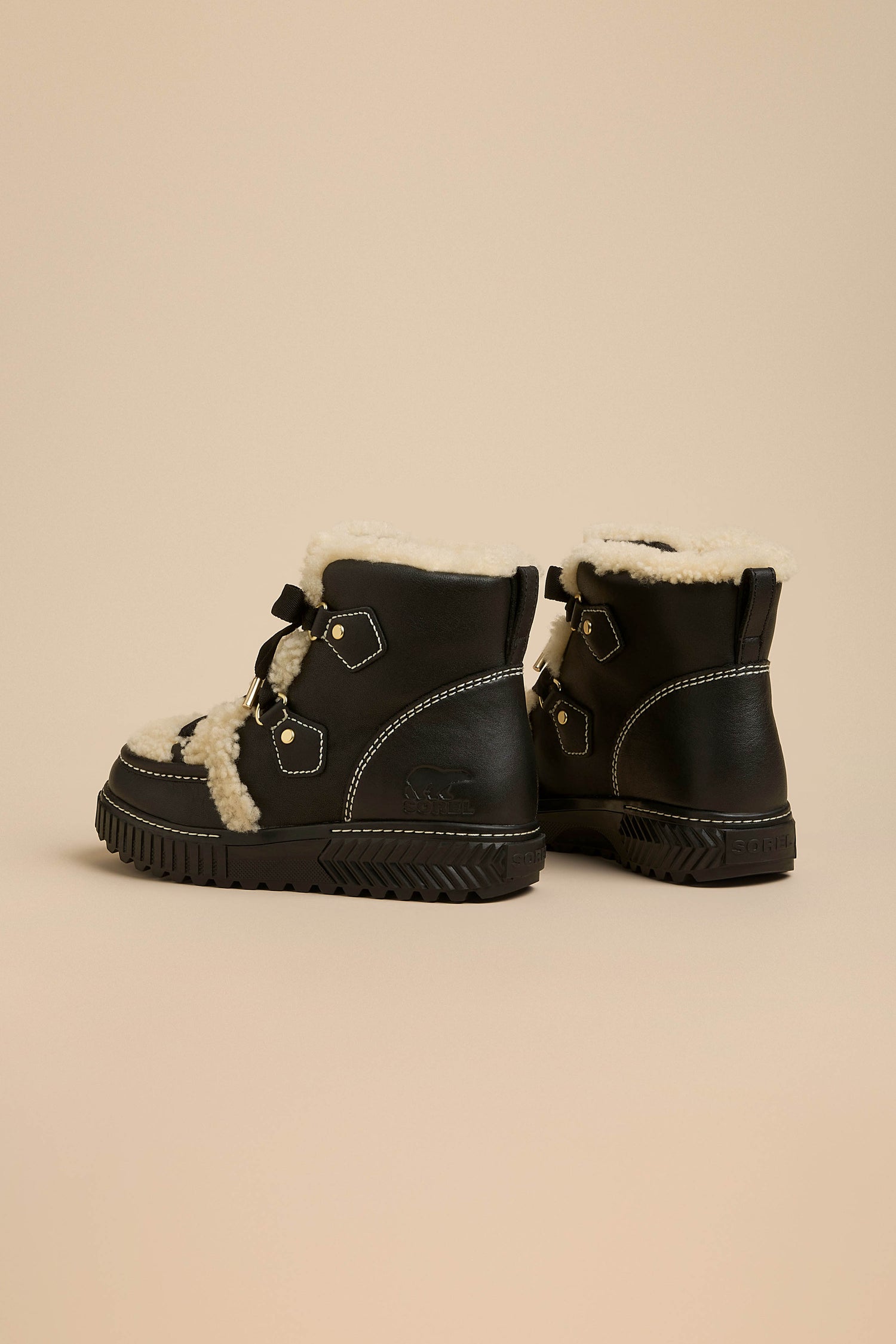 Black Sorel Leather Alpine Boots featuring cream-colored fleece lining, metal eyelets, and thick black rubber lug soles.