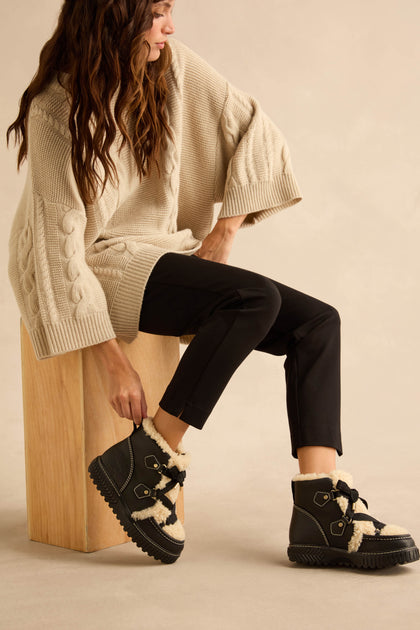 Black Sorel Leather Alpine Boots with shearling trim and thick lugged soles.