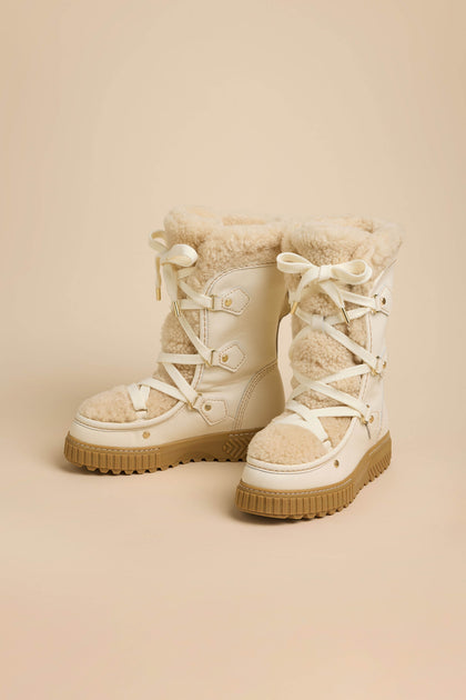 Off-white waterproof Long Leather Alpine Boots with genuine shearling lining and thick, tan lugged rubber soles.