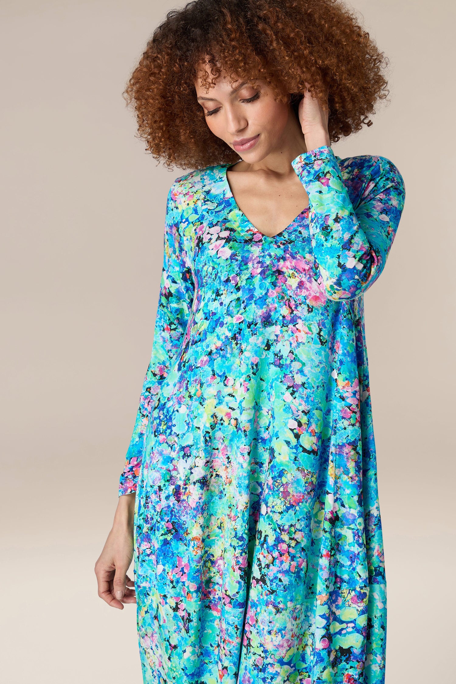 A woman wearing a Spring Petal Burst Jersey Dress blue floral dress.