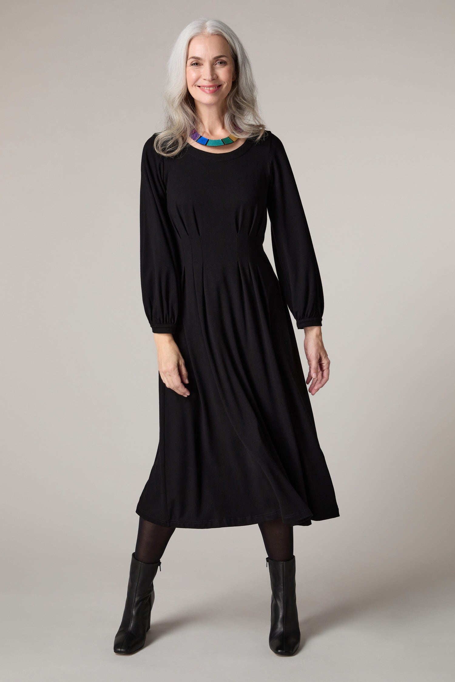 A woman wearing a Fluid Crepe Pleat Waist Dress.