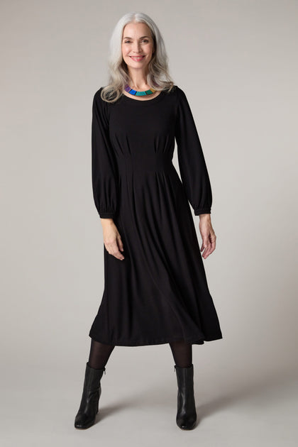 A woman wearing a Fluid Crepe Pleat Waist Dress.