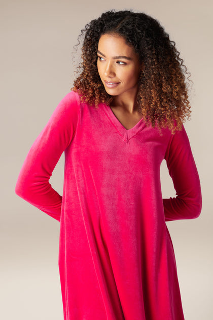 A woman wearing a luxury pink Velvet Jersey Bubble Hem Dress.