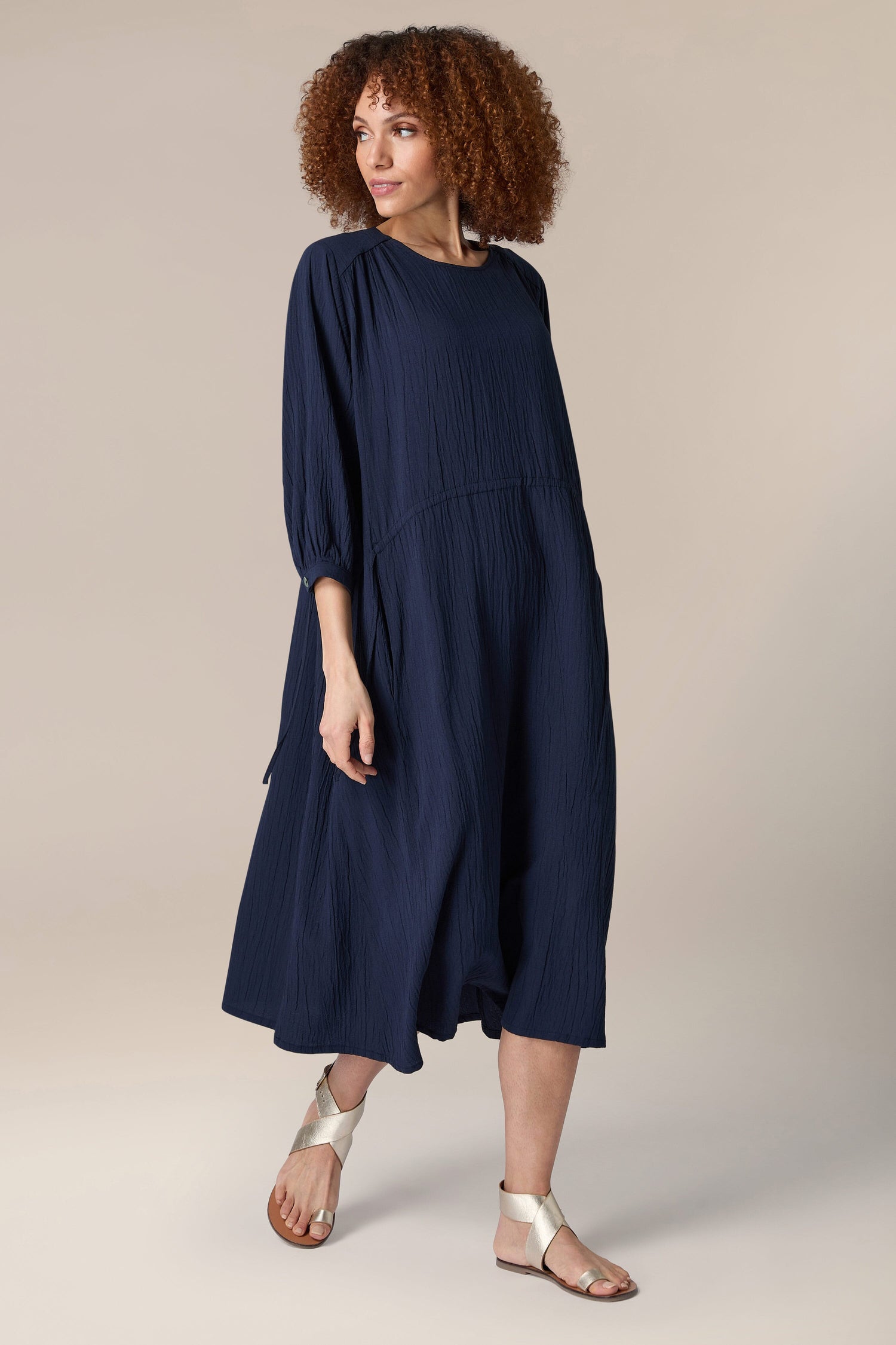 A woman wearing a navy Crinkle Soft Viscose Flared Dress and sandals.