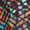 A close-up of a multi-colored mosaic with irregularly shaped tiles in hues of red, blue, orange, and white, reminiscent of the intricate pattern on the Diamond Jacquard Jersey Cocoon Dress.