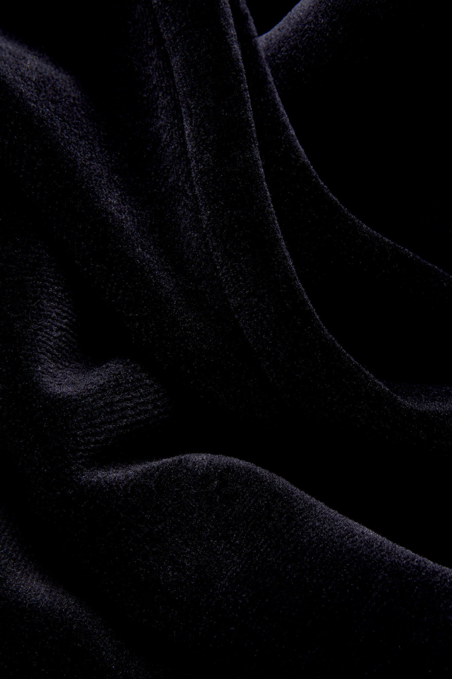 Close-up of dark, soft fabric with visible folds and a velvety texture, evoking the luxurious feel of the Velvet Jersey Pocket Dress.