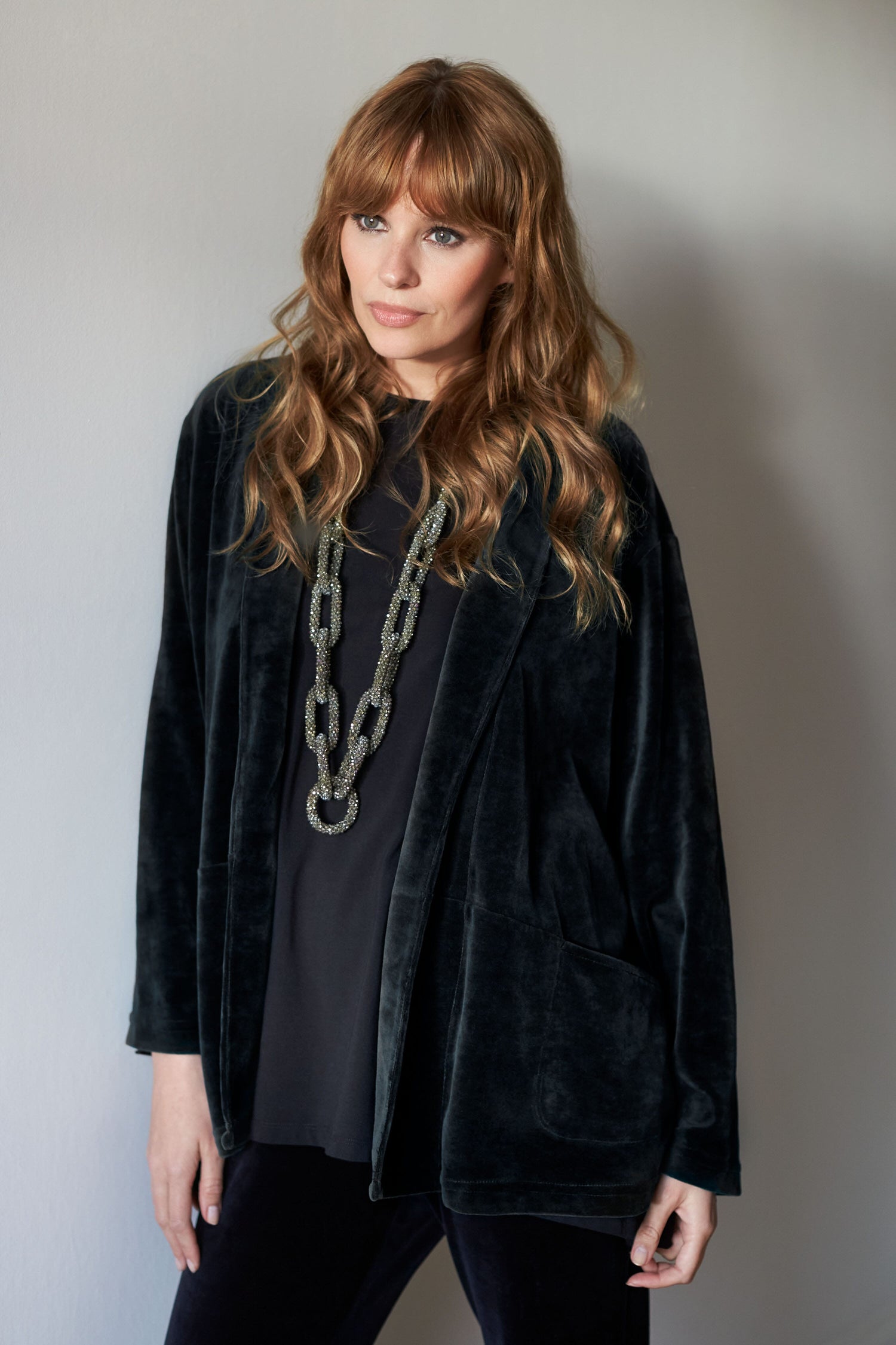 A woman in a Velvet Jersey Relaxed Jacket and pants with relaxed tailoring.