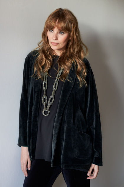 A woman in a Velvet Jersey Relaxed Jacket and pants with relaxed tailoring.