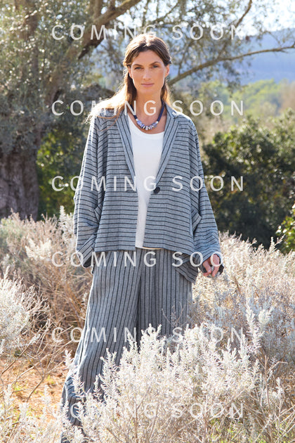 Person outdoors in a striped outfit with the Linen Viscose Stripe Boxy Jacket and pants, surrounded by dried foliage and trees. Text overlay reads "COMING SOON.