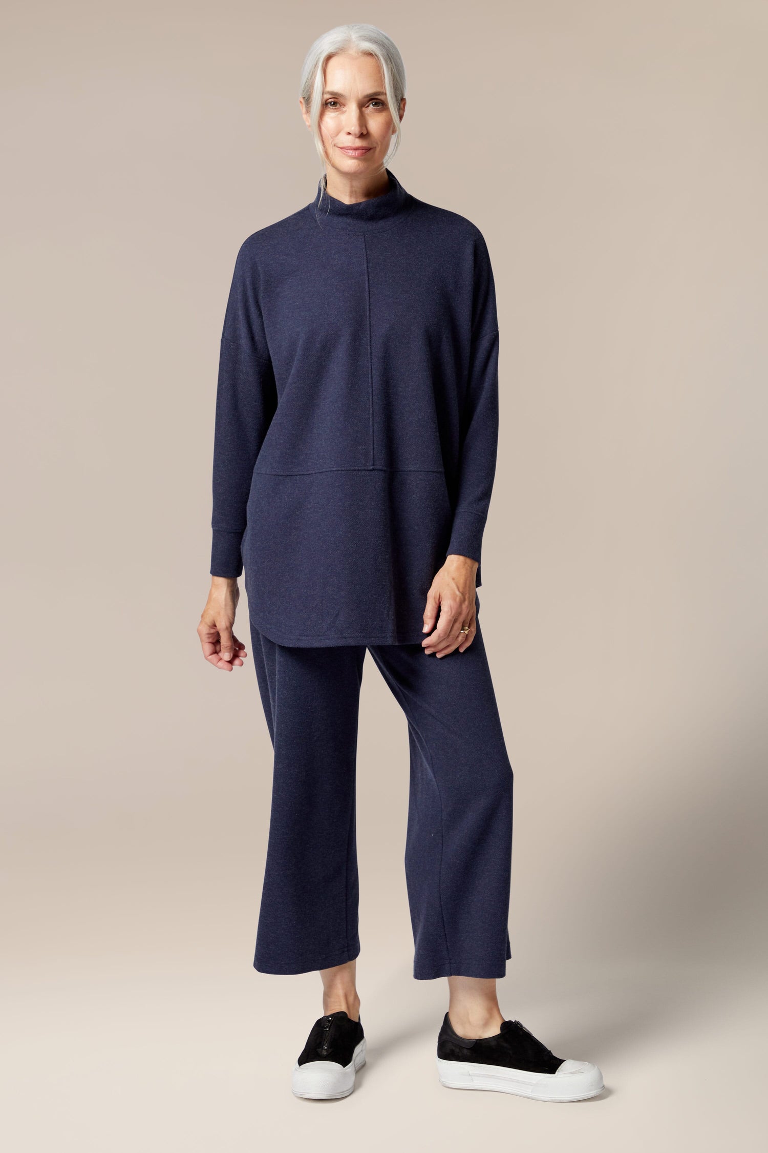 A woman wearing a flared silhouette long-sleeved sweater and Marl Jersey Wide Leg Trouser.