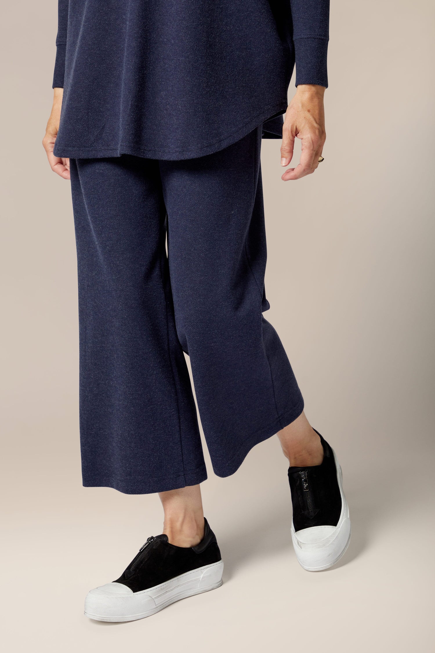 A woman wearing a marl jersey navy sweater and Marl Jersey Wide Leg Trousers.