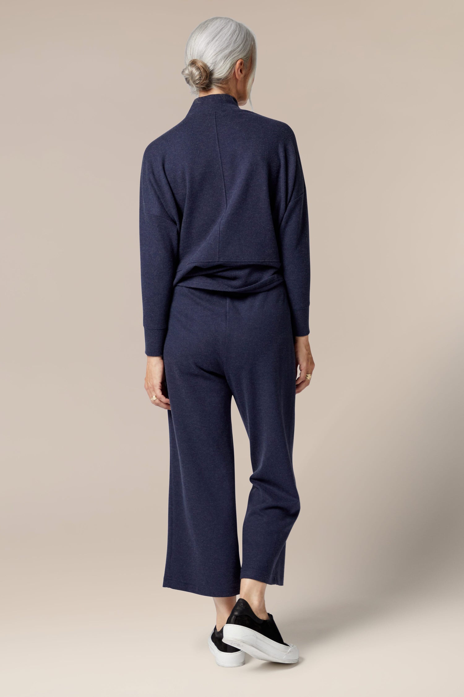 The back view of a woman wearing Marl Jersey Wide Leg Trouser with a flared silhouette.