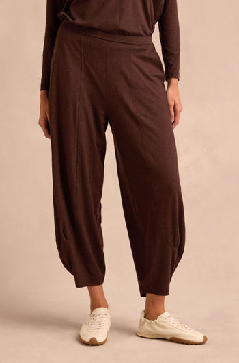 Wearing the Soft Viscose Jersey Bubble Trouser in a relaxed fit, paired with cream sneakers, the model stands against a neutral background, with only the lower half of the body visible.