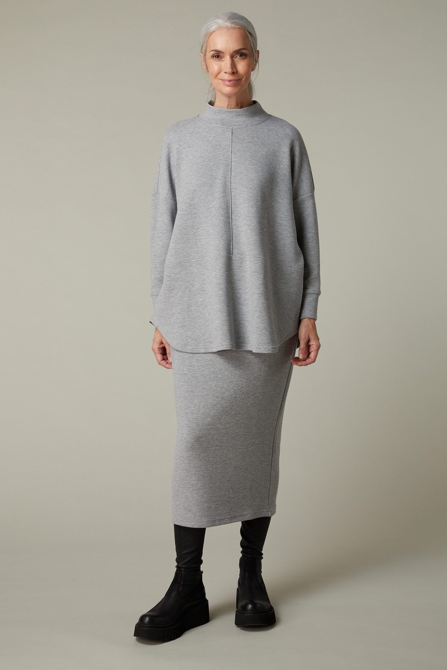The model is wearing a grey jersey sweater and Crinkle Jersey Tube Skirt.