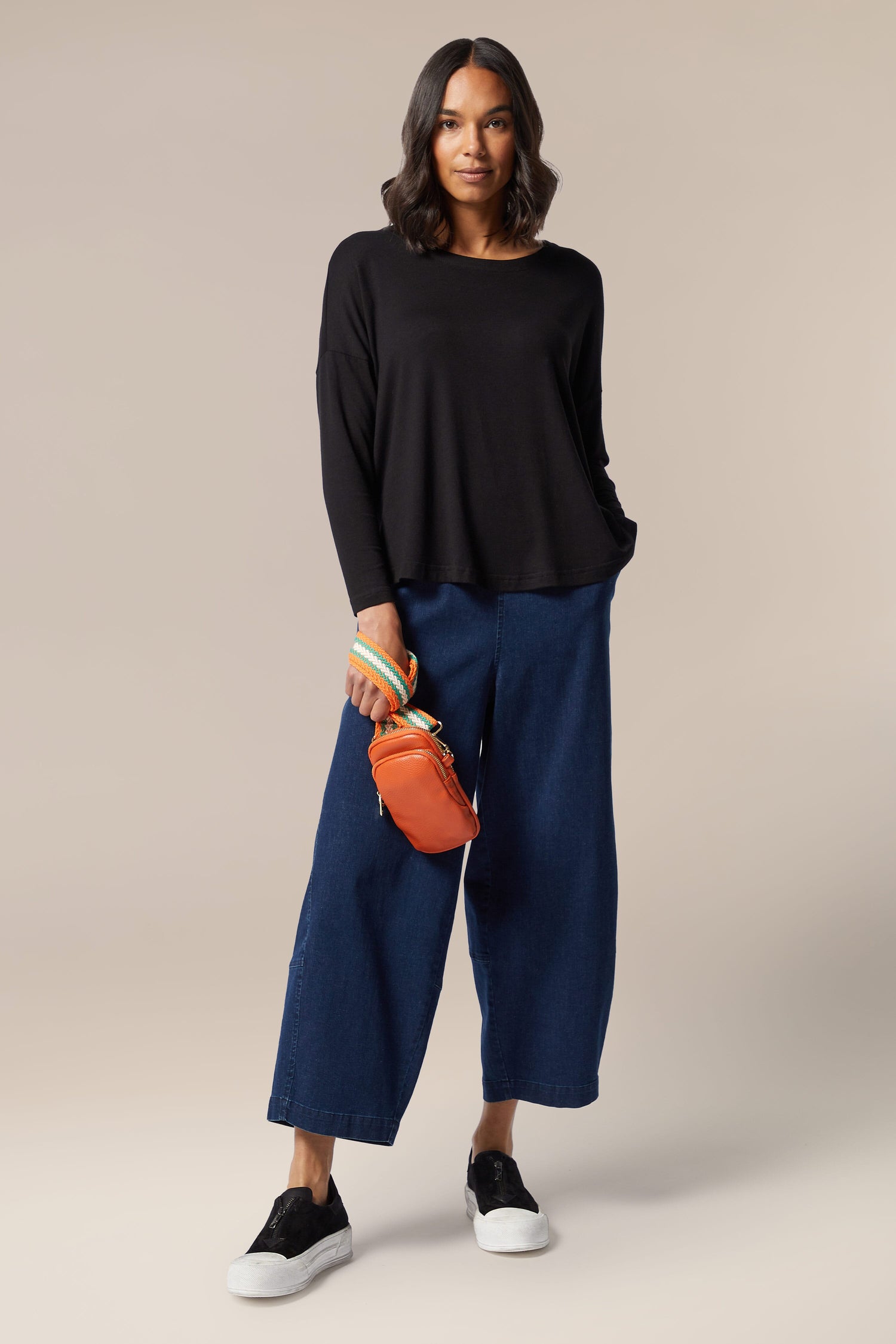 A woman wearing a Fluid Crepe Relaxed Top from her wardrobe.