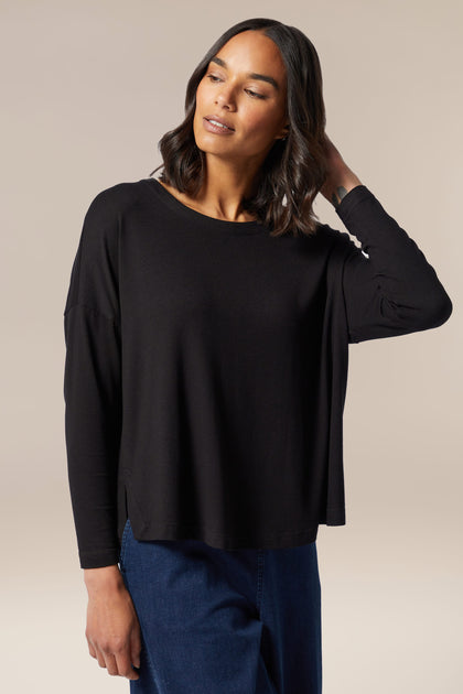 The Fluid Crepe Relaxed Top in black is a stylish addition to any wardrobe.