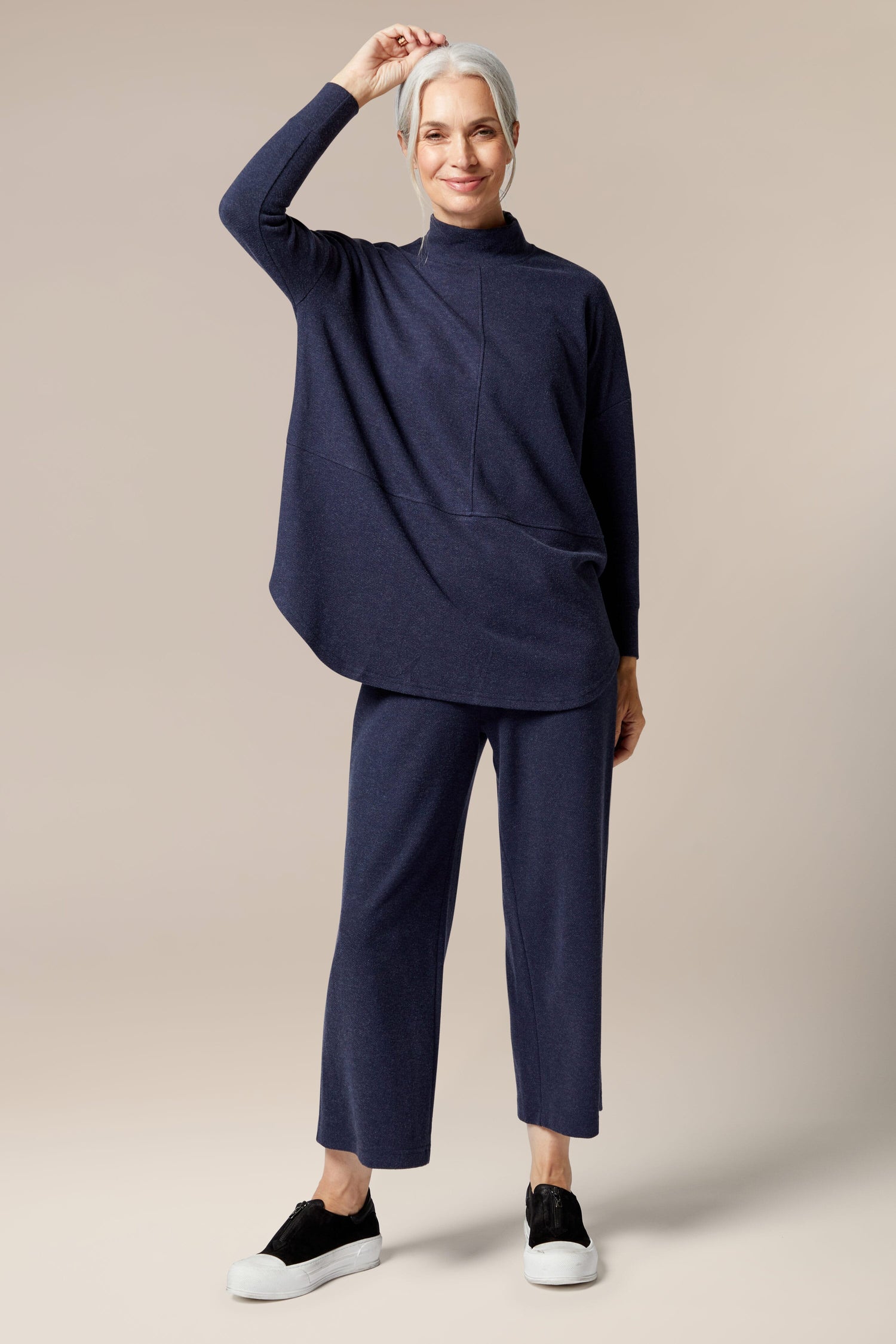 A woman wearing a Marl Jersey Sweatshirt and pants, creating a wardrobe staple look.